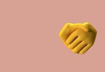 6 Psychological Triggers That Make Comments Go Viral 3D illustration of a yellow handshake emoji on a beige background, symbolizing agreement.