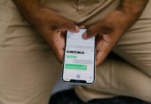 How Comments Convert Followers into Customers Close-up view of hands texting on a smartphone, focusing on the screen displaying messages.