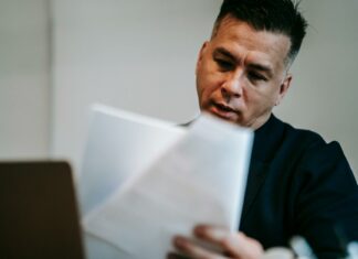 5 Powerful Benefits of Cross-Platform AI Commenting Professional man intently reviewing paperwork at his workstation indoors.